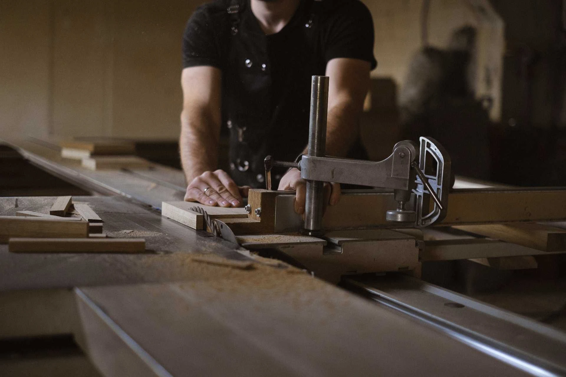 A craftsman meticulously finishing a cabinet drawer.